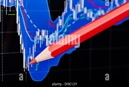 Tableau financier et le crayon rouge.fond noir. Selective focus Banque D'Images