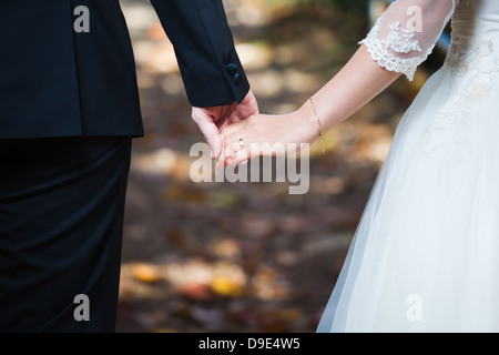 Young married couple holding hands on wedding day Banque D'Images