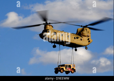 L'Armée américaine Un hélicoptère CH-47 Chinook transporte un Humvee. Banque D'Images