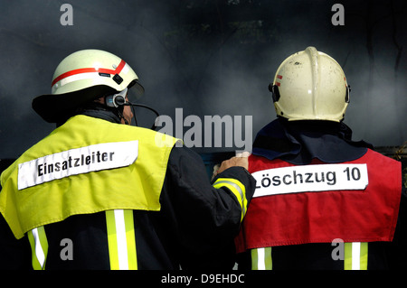 Pompiers en utiliser l'application. Chef des opérations un muntert sur compagnon fatigué. Banque D'Images