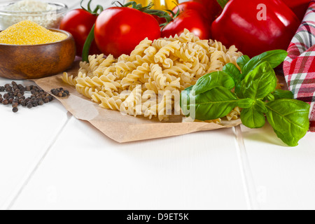 L'Italien Ingrédients alimentaires - ingrédients pour la cuisine italienne, le basilic, die bronze pâtes fusilli. poivron rouge, les tomates, l'huile d'olive... Banque D'Images