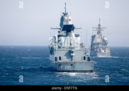 La frégate allemande Hessen FFG et USS Normandy au large des côtes écossaises. Banque D'Images