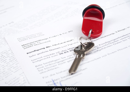 Un avis écrit d'un contrat de location avec un avis écrit de résiliation d'un contrat de location avec une clé Banque D'Images