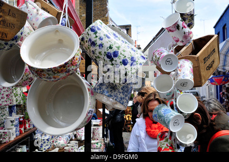 Une femme parcourt dans une boutique d'antiquités, marché de Portobello Road, Londres, Royaume-Uni. Banque D'Images