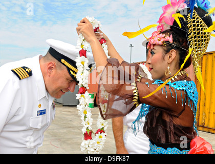 Le capitaine de l'US Navy va Pennington, commandant de la 7e flotte navire amiral USS Blue Ridge est accueilli avec un lei de fleurs traditionnelles après son arrivée pour une visite du port le 14 juin 2013 à Jakarta, Indonésie. Banque D'Images