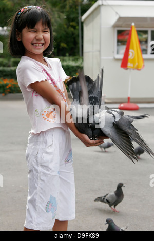 Fille Kazakh pigeon d'alimentation dans le parc (Parc Panfilov), Almaty, Kazakhstan, en Asie centrale Banque D'Images