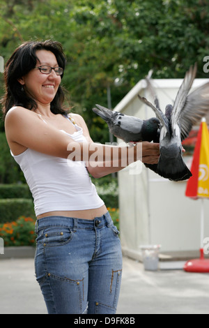 Jeune femme Kazakh pigeon d'alimentation dans le parc (Parc Panfilov), Almaty, Kazakhstan, en Asie centrale Banque D'Images