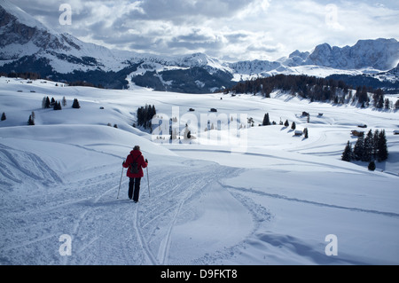 Une femme marche sur un sentier de neige à l'Alpe di Siusi Ski près de la ville d'Otisei dans les Dolomites, le Tyrol du Sud, Italie Banque D'Images