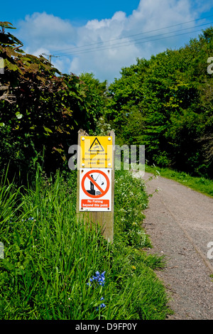 Pas de pêche et pêcheurs méfiez-vous des câbles électriques panneaux d'avertissement sur le chemin de halage du canal Carnforth Lancashire Angleterre Grande-Bretagne Royaume-Uni Banque D'Images