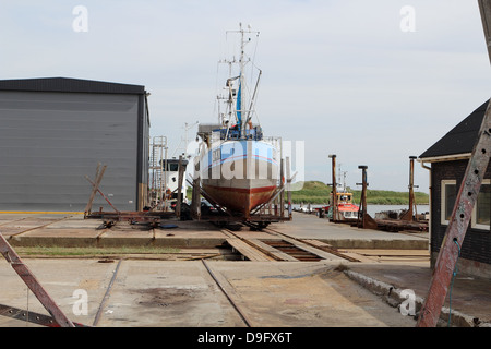 Bateau de pêche sur la cale de halage à Hvide Sande chantier naval. Fiskekutter literie på Hvide Sande Skibs og Baadebyggeri Danemark Banque D'Images