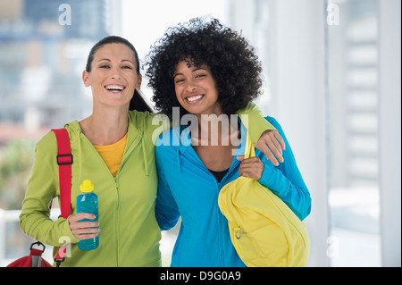 Deux heureux amis féminins transportant des sacs de sport Banque D'Images