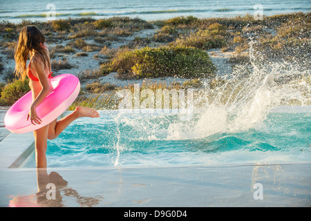 Woman dans une piscine sur la plage Banque D'Images