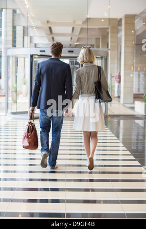 Couple en train de marcher dans un aéroport Banque D'Images