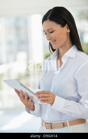 Businesswoman using a digital tablet in an office Banque D'Images