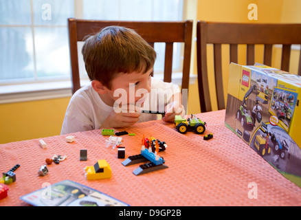 Austin Texas USA, 2013: Un garçon mexicain-américain de 7 ans figure comment assembler les blocs de construction de Legos. ©Marjorie Kamys Cotera/Daemmrich photos Banque D'Images