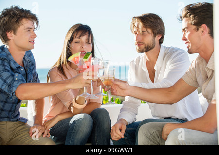Groupe d'amis toasting drinks outdoors on vacation Banque D'Images