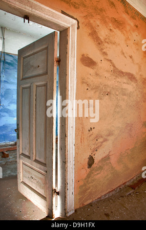 Ouvrir la porte d'une salle pleine de sable dans Kolmanskop ghost, une ville minière en Namibie, l'Afrique. Le désert a repris la ville. Banque D'Images
