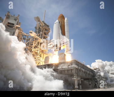 Un panache d'échappement formulaires conformément à la plate-forme de lancement mobile sur la plateforme de lancement 39A, comme la navette spatiale Atlantis décollera en orbite. Banque D'Images