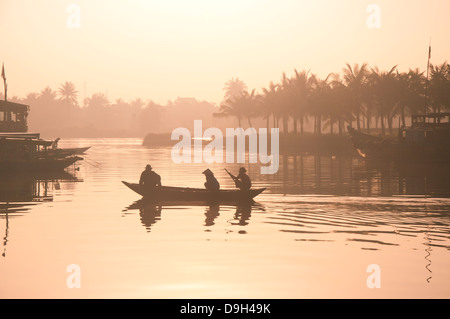 Trois personnes dans un petit bateau dans la rivière près de Hoi An, Vietnam Banque D'Images