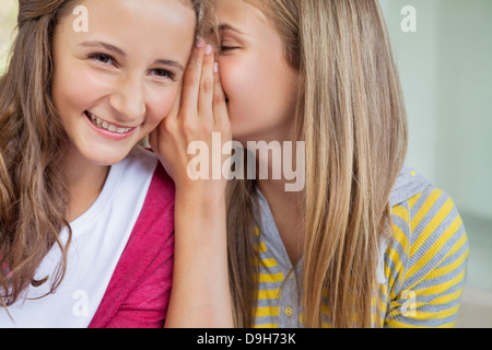 Close-up of two girls whispering dans une école Banque D'Images