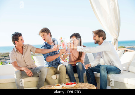 Groupe d'amis toasting drinks outdoors on vacation Banque D'Images
