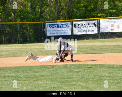 Glisser dans la deuxième base dans une école d'un match de baseball Banque D'Images