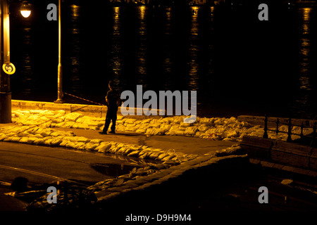 Agent de police patrouiller dans la rue, entouré de sacs de sable sur le bord du Danube, Budapest, Hongrie Banque D'Images