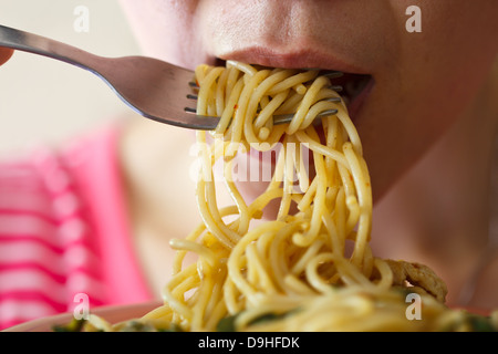 Belles jeunes femmes mangent des spaghetti dans epicé Banque D'Images