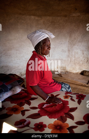 Femme Sangoma est assis sur son lit à la maison rurale dans le Transkei, Afrique du Sud Banque D'Images