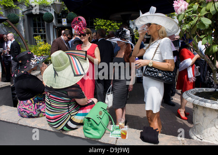 Chers chapeaux de profiter d'un bar avec la société matin personnes au cours de la Royal Ascot annuel festival de courses de chevaux dans le Berkshire, en Angleterre. Royal Ascot est l'une des plus célèbres courses, et remonte à 1711. La reine Elizabeth et divers membres de la famille royale britannique. Tenue chaque année au mois de juin, c'est l'une des principales dates du calendrier sportif anglais et en été, des saisons. Plus de 300 000 personnes font la visite annuelle à Berkshire Ascot Royal pendant la semaine, ce qui en fait l'Europe's best-assisté réunion de courses avec plus de £3m prix en argent à gagner. Banque D'Images