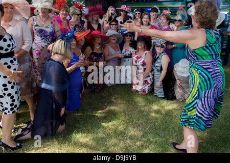 Une journée des femmes du Pays de Galles groupe profitez d'un matin d'été, heures avant la course de chevaux débute pendant le festival annuel de Royal Ascot dans le Berkshire, en Angleterre. Royal Ascot est l'une des plus célèbres courses, et remonte à 1711. La reine Elizabeth et divers membres de la famille royale britannique. Tenue chaque année au mois de juin, c'est l'une des principales dates du calendrier sportif anglais et en été, des saisons. Plus de 300 000 personnes font la visite annuelle à Berkshire Ascot Royal pendant la semaine, ce qui en fait l'Europe's best-assisté réunion de courses avec plus de £3m prix en argent à gagner. Banque D'Images