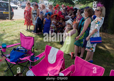 Une journée des femmes du Pays de Galles groupe profitez d'un matin d'été, heures avant la course de chevaux débute pendant le festival annuel de Royal Ascot dans le Berkshire, en Angleterre. Royal Ascot est l'une des plus célèbres courses, et remonte à 1711. La reine Elizabeth et divers membres de la famille royale britannique. Tenue chaque année au mois de juin, c'est l'une des principales dates du calendrier sportif anglais et en été, des saisons. Plus de 300 000 personnes font la visite annuelle à Berkshire Ascot Royal pendant la semaine, ce qui en fait l'Europe's best-assisté réunion de courses avec plus de £3m prix en argent à gagner. Banque D'Images