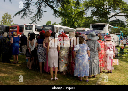 Une journée des femmes du Pays de Galles groupe profitez d'un matin d'été, heures avant la course de chevaux débute pendant le festival annuel de Royal Ascot dans le Berkshire, en Angleterre. Royal Ascot est l'une des plus célèbres courses, et remonte à 1711. La reine Elizabeth et divers membres de la famille royale britannique. Tenue chaque année au mois de juin, c'est l'une des principales dates du calendrier sportif anglais et en été, des saisons. Plus de 300 000 personnes font la visite annuelle à Berkshire Ascot Royal pendant la semaine, ce qui en fait l'Europe's best-assisté réunion de courses avec plus de £3m prix en argent à gagner. Banque D'Images