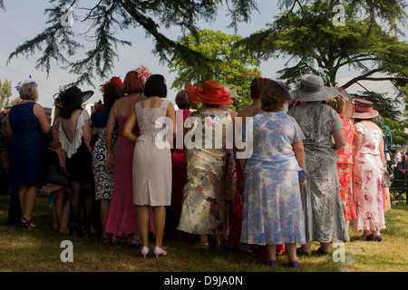 Une journée des femmes du Pays de Galles groupe profitez d'un matin d'été, heures avant la course de chevaux débute pendant le festival annuel de Royal Ascot dans le Berkshire, en Angleterre. Royal Ascot est l'une des plus célèbres courses, et remonte à 1711. La reine Elizabeth et divers membres de la famille royale britannique. Tenue chaque année au mois de juin, c'est l'une des principales dates du calendrier sportif anglais et en été, des saisons. Plus de 300 000 personnes font la visite annuelle à Berkshire Ascot Royal pendant la semaine, ce qui en fait l'Europe's best-assisté réunion de courses avec plus de £3m prix en argent à gagner. Banque D'Images