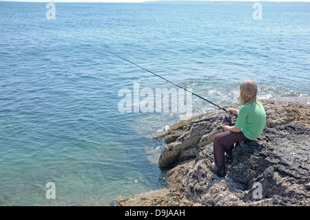 A 10 ans, fille de poissons les rochers au point de Pendennis à Falmouth, Cornwall, UK Banque D'Images