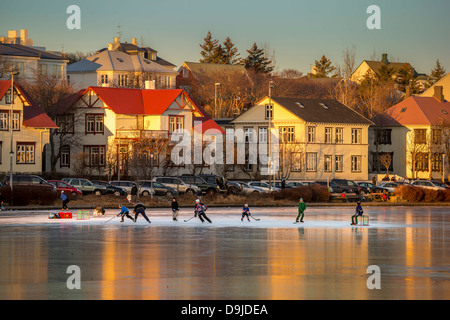 Jouer au hockey sur glace sur l'étang de Reykjavik, en Islande. Banque D'Images