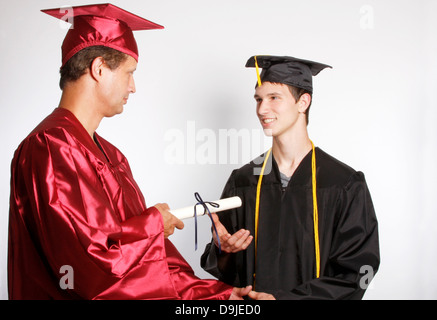 Un doyen en serrant la main d'un diplômé recevant un diplôme Banque D'Images