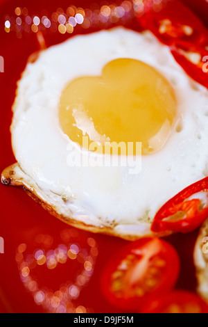 Œuf frit avec forme de coeur d'œufs et le bokeh en forme de coeur, bon petit déjeuner. Banque D'Images