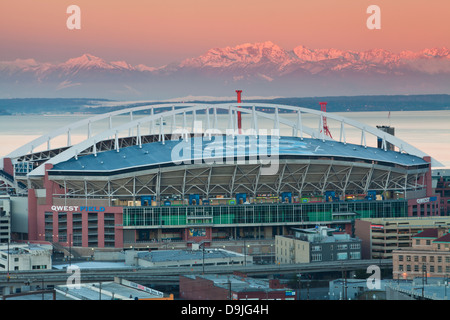 Qwest Field au lever du soleil avec un ciel rose sur les montagnes Olympiques et Puget Sound, Seattle, Washington. Banque D'Images