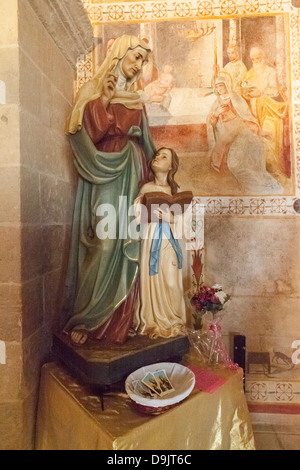 Une statue dans l'église de Sant' Anna, Specchia Gallone, près de Lecce, Pouilles, Italie. Fresques racontent l'histoire sur chaque mur principal. Banque D'Images