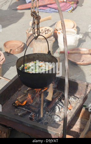 Soupe de légumes cuits à l'histoire de Viking dans une casserole sur un feu de bois à un événement de reconstitution Viking. Banque D'Images