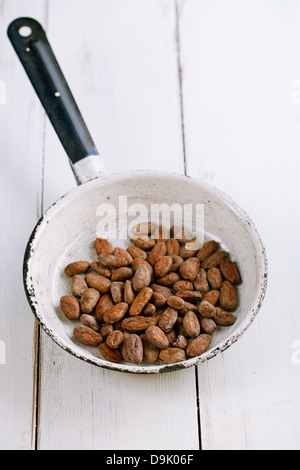 Cacao torréfié de chocolat dans le moule, sur fond de bois blanc Banque D'Images