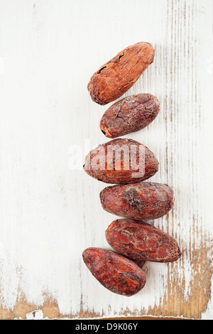 Chocolat cacao torréfié haricots sur fond de bois blanc Banque D'Images