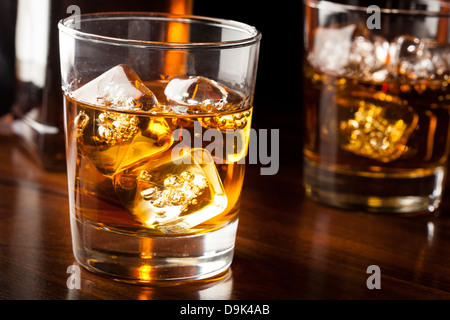 Whisky brun doré sur les rochers dans un verre Banque D'Images