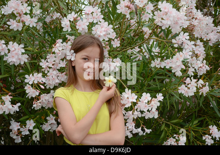 Belle fille de fleurs blanches à fleur blanche dans les cheveux et avec fleur jaune dans la main Banque D'Images