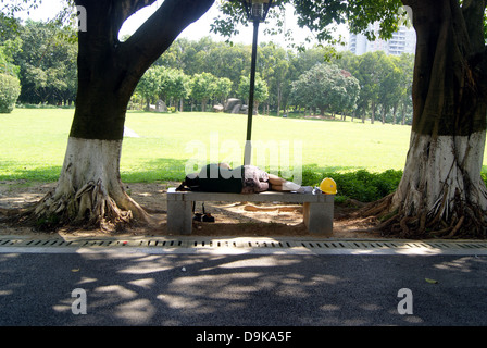 Dormir sur le banc de parc, Shenzhen en Chine. Banque D'Images