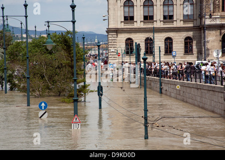 Les spectateurs et les touristes à la recherche de plus à la rue inondée et de tramway sur l'explosion des rives du Danube, Budapest, Hongrie Banque D'Images