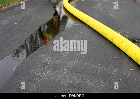 Un pompier à près d'un flexible de flottaison lors d'une scène d'incendie. Reflet dans l'eau Banque D'Images