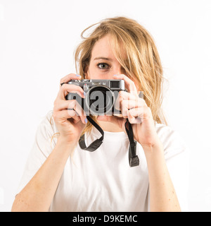 Une jeune femme photographe avec de longs cheveux blonds à l'aide d'un petit Fuji X100 s appareil photo numérique Banque D'Images