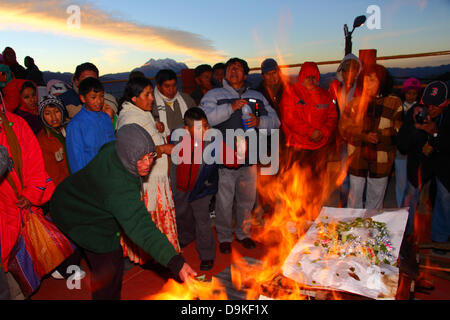 LA PAZ, BOLIVIE, 21 juin. Les boliviens jeter des offrandes de feuilles de coca sur un incendie lors d'un événement pour célébrer le Nouvel An Aymara ou Willka Kuti (aussi le solstice d'hiver). Lever du soleil marque le début de la nouvelle année (5521 dans le calendrier Aymara). Dans l'arrière-plan est le mont Illimani, le tuteur pic de La Paz et symbole de la ville. Credit : James Brunker / Alamy Live News Banque D'Images